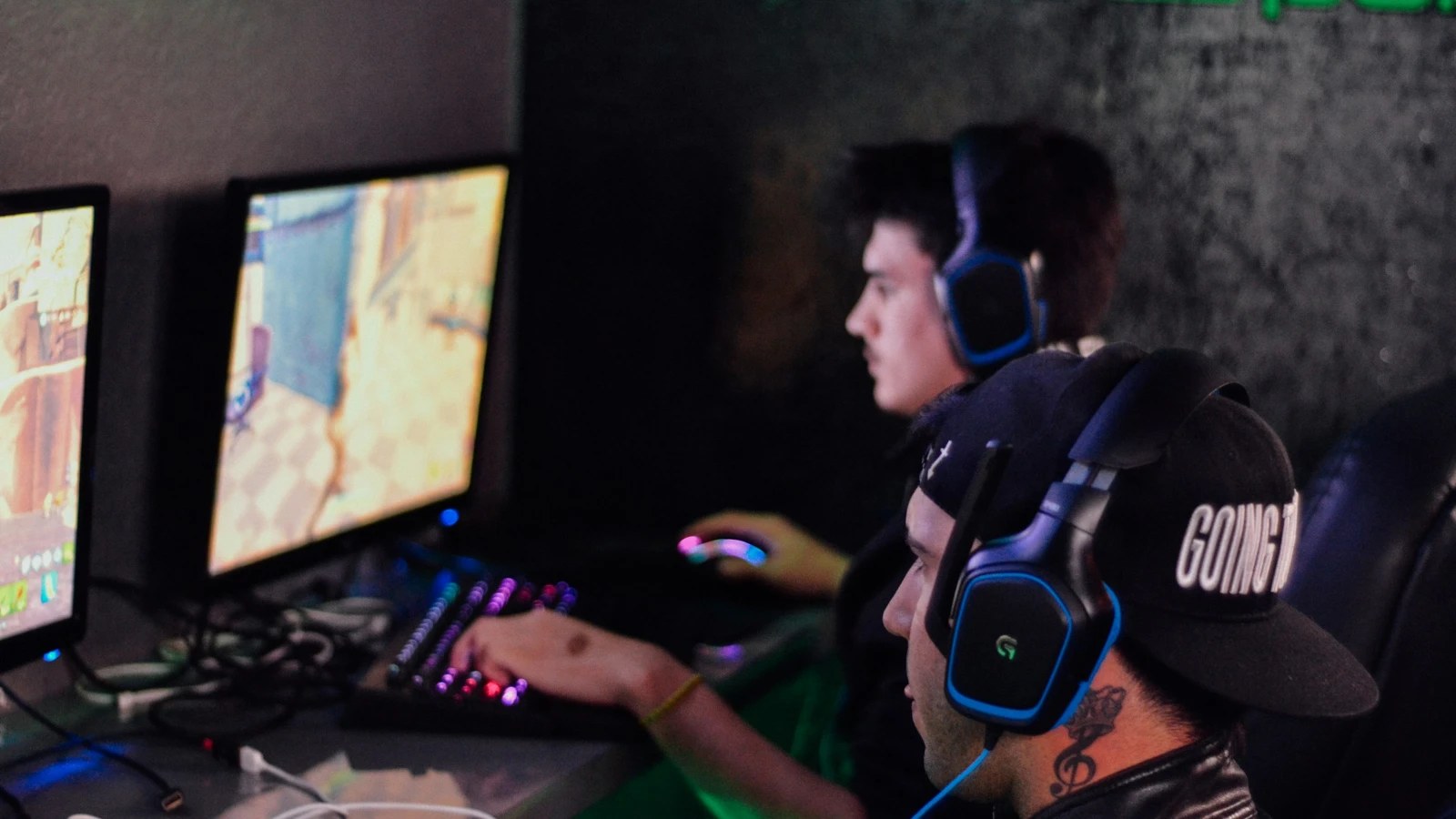 Two players with headsets gaming on PC monitors