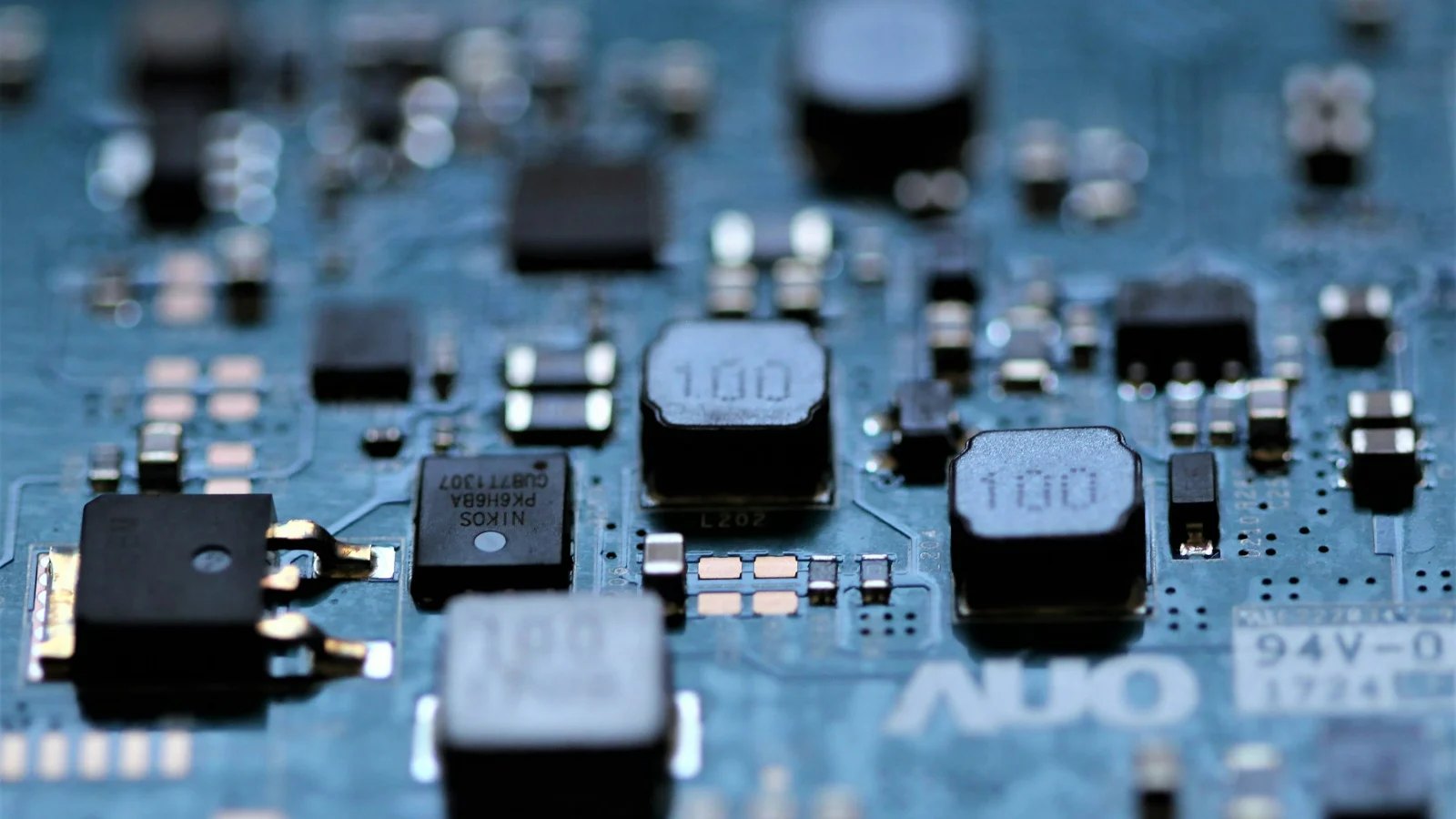 Close-up of small square coils on a blue circuit board
