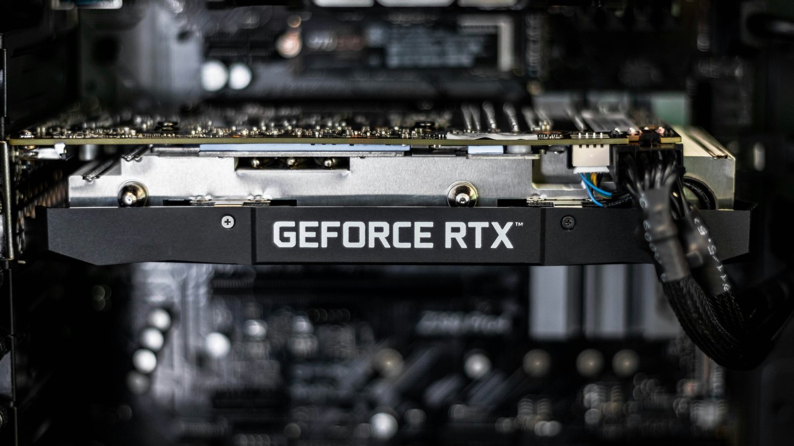 A GeForce RTX graphics card installed inside a desktop PC, with its power cable connected
