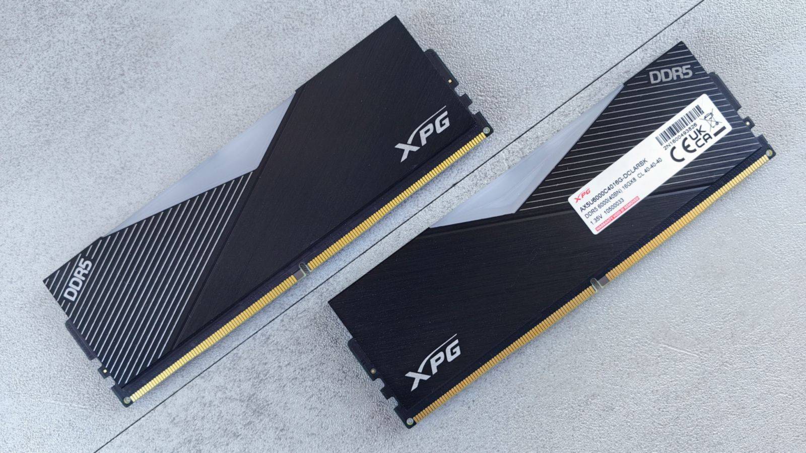 Two black DDR5 RAM modules on a light surface