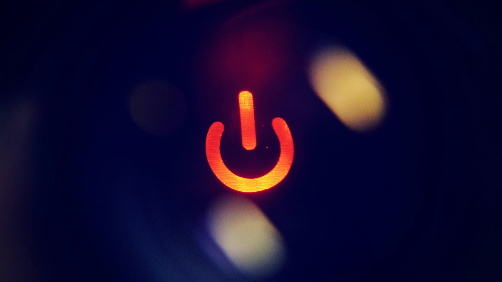 A glowing red power symbol on a dark background